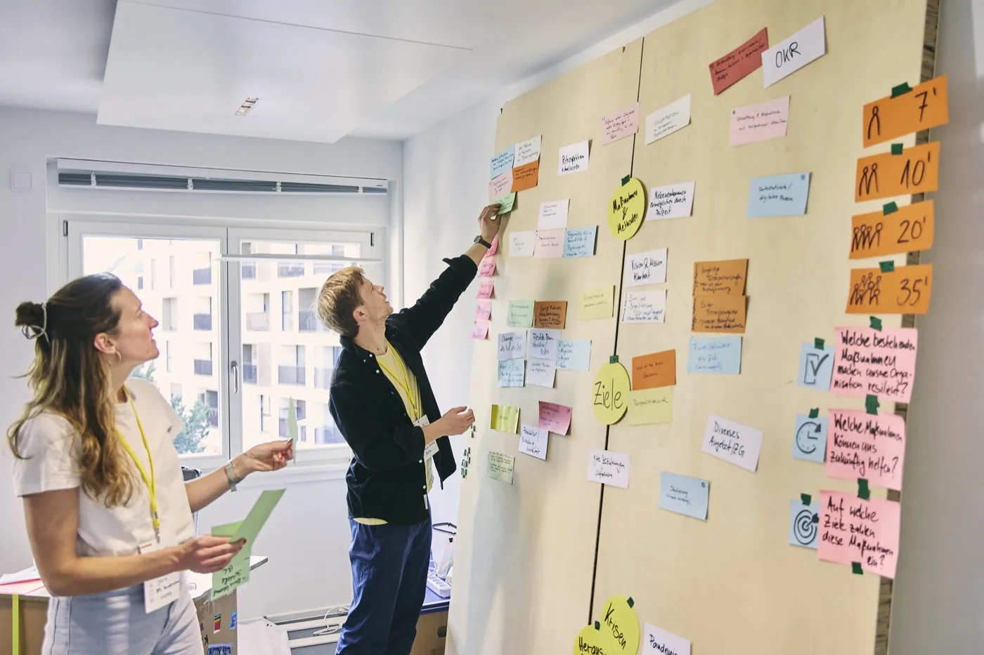 Teilnehmende bei der Strategiearbeit am Whiteboard